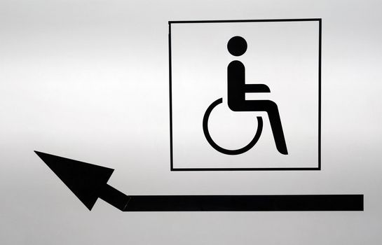 Disabled icon with an arrow pointing to the left. White wall painted on black