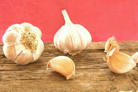 garlic on wood table (dark red background)