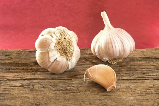 garlic on wood table (dark red background)