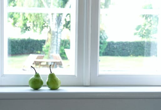 two, green pears on window sill