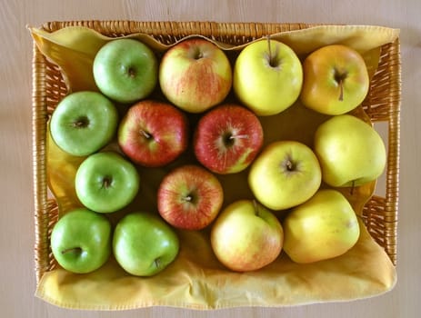 red, green  and yellow apples in basket