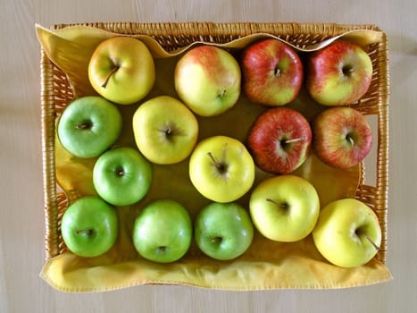 red, green  and yellow apples in basket