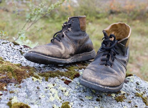 Standing on a stone, the old torn boots