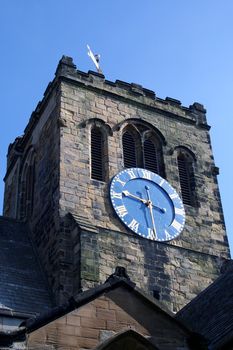 Close up of quaint church tower and clock, England.