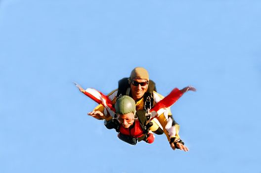 Portrait of two tandem skydivers in action parachuting through the air.