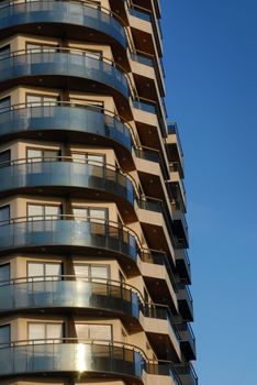 Modern building with balcony on a blue sky background
