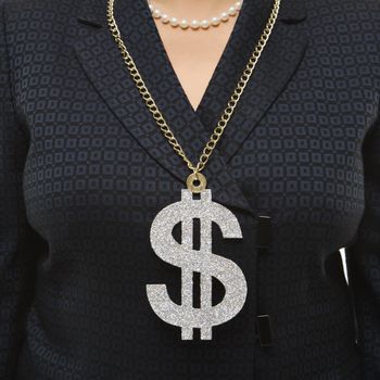 Close-up of Filipino middle-aged businesswoman wearing chain necklace with oversized dollar sign.