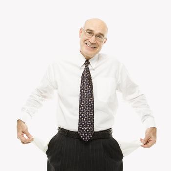 Caucasian middle-aged businessman pulling empty pockets out standing against white background.