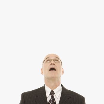 Caucasian middle-aged businessman looking up with mouth open against white background.