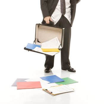 Caucasian middle-aged businessman holding open briefcase with papers falling out.