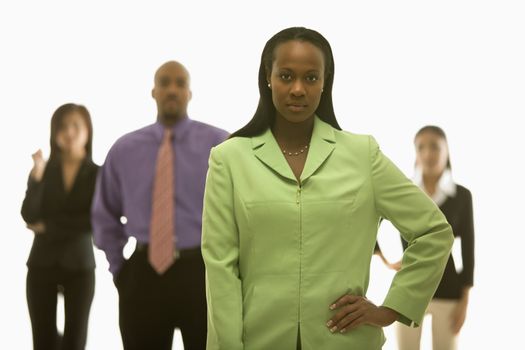 African-American businesswoman with hand on hip with others in background.