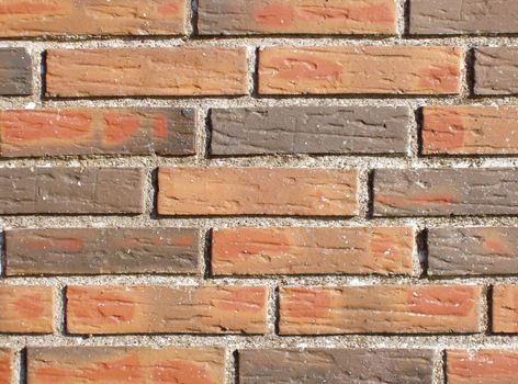 Piece of a wall build of hard burned, hand moulded bricks with a rough surface. This structure will make a nice background for your own 'grafitti' illustration or text.