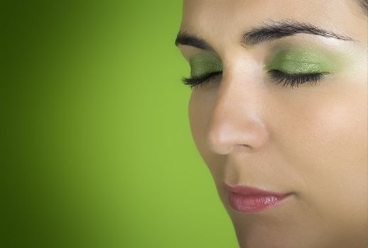 Beautiful woman portrait with closed eyes on a green background