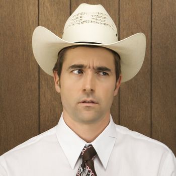 Mid-adult Caucasian male wearing a cowboy hat lookinig off to side.