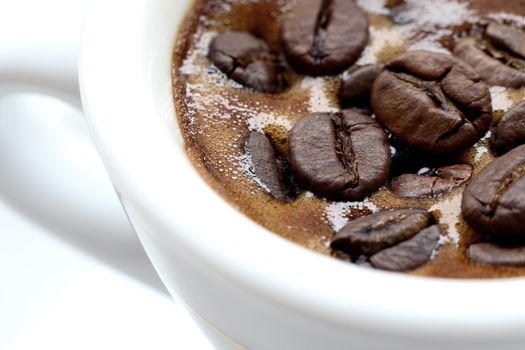 white espresso cup & saucer filled with coffee beans