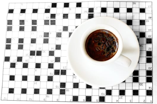 a cup of coffe with crossword in background