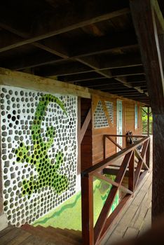 Iguana painted on the wall of a wooden house. Staircase railing in rustic style