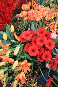 Red and orange flower arrangement on a flower parade: red gerberas, orange tulips and tigerlilies