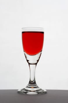 a glass of wine on the table, over white background