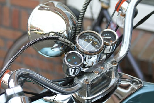 A cockpit of a vintage motorbike with chroom and rusty details