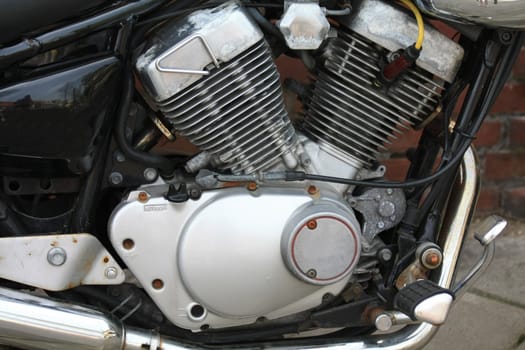 Detail of a vintage motorcycle engine, in black and metal