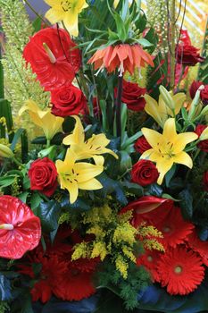 red roses and yellow tigerlilies in a mixed arrangement