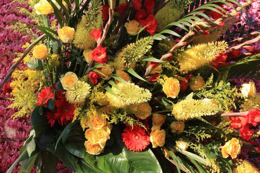 yellow roses and orange gerberas in a flower arrangement