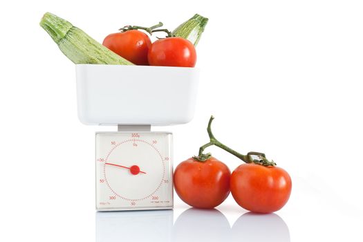 vegetables on kitchen scale isolated on white background with clipping path