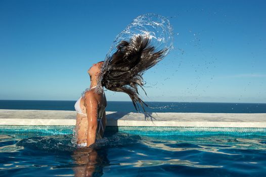 Woman relaxing on a swimming pool with a sea view in Arraial d'Ajuda, Bahia, Brazil, Nikon D3S, RAW shooting.