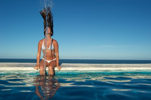 Woman relaxing on a swimming pool with a sea view in Arraial d'Ajuda, Bahia, Brazil, Nikon D3S, RAW shooting.