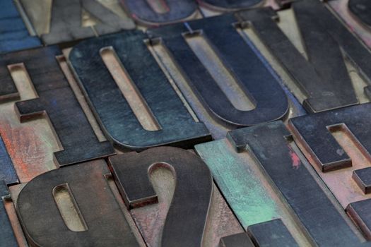 abstract background of vintage wood letterpress type blocks stained by colorful inks 