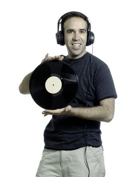 A young man wearing a set of headphones and holding an old LP record, isolated against a white background
