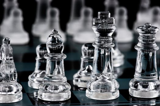 Glass chess pieces on glass board