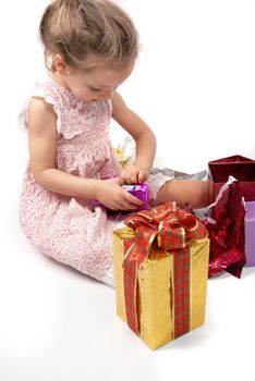 Little girl opening Christmas presents. White background