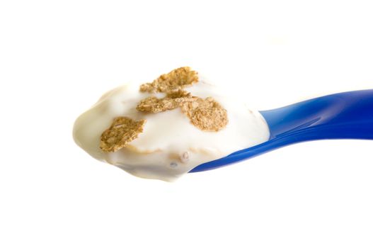 closeup on a blue spoon full of yoghurt with cereal