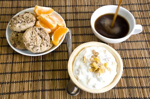 breakfast setup, pouring coffee, yoghurt, cookies and fruits