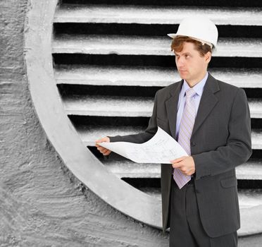 Engineer - designer in the helmet with the drawings in hand