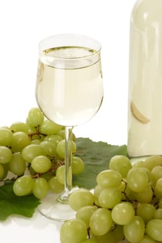 Glass of white wine with grapes and bottle on white background