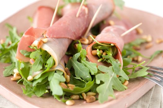 Appetizer with ham rolls and rocket salad