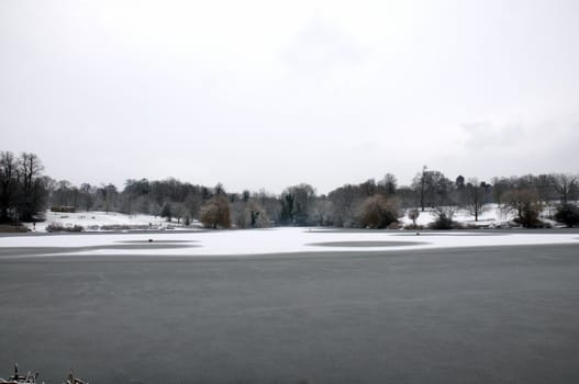 A view of a lake in winter with snow