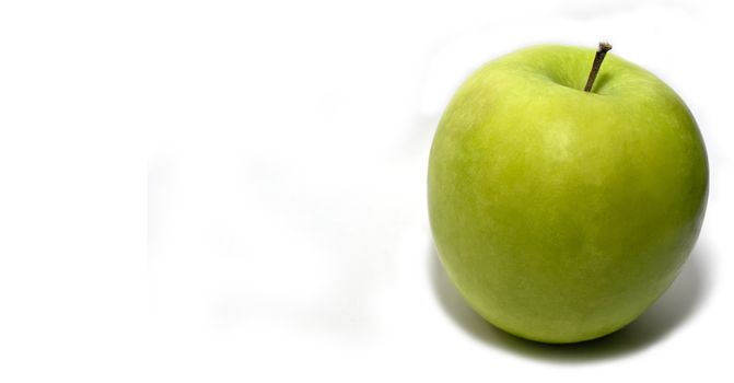 A ripe granny SMith apple over a plain white background  