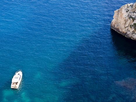 Family on a leisure boat on crystal clear deep blue waters in Malta in the Mediterranean