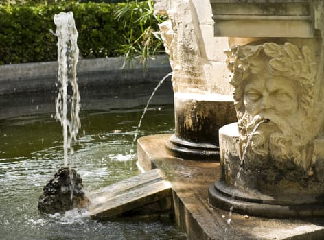 Detail of a medieval fountain in a public garden in Malta