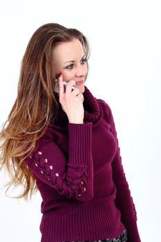 The attractive woman with pullower talks by a mobile phone on a white background 