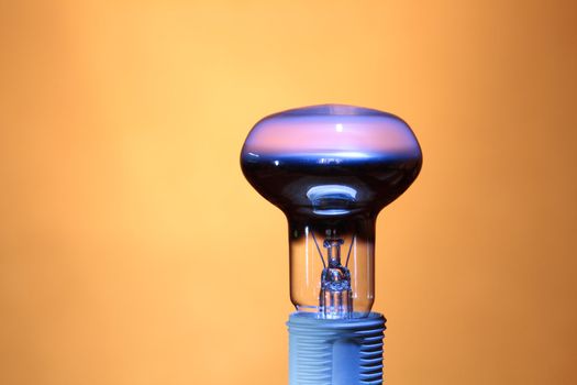 Closeup of lightbulb isolated on ginger background with copy space