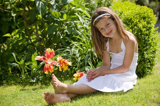 Young girl sitting on a field with flowers
