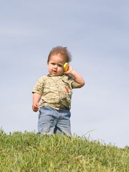 Little boy holding a toy cellphone near his ear