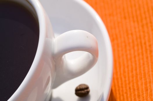 closeup on a coffee cup on orange background