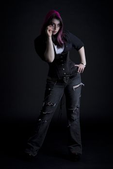 Goth girl with pink hair and body piercing holding her glasses 