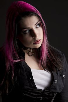 Goth girl with pink hair and body piercing looking to the right